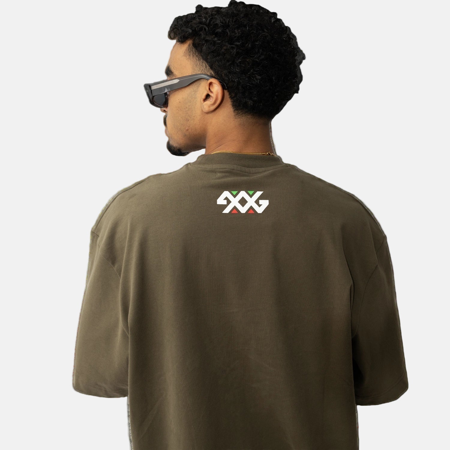 Man wearing a green t-shirt with a logo on the back against a white background