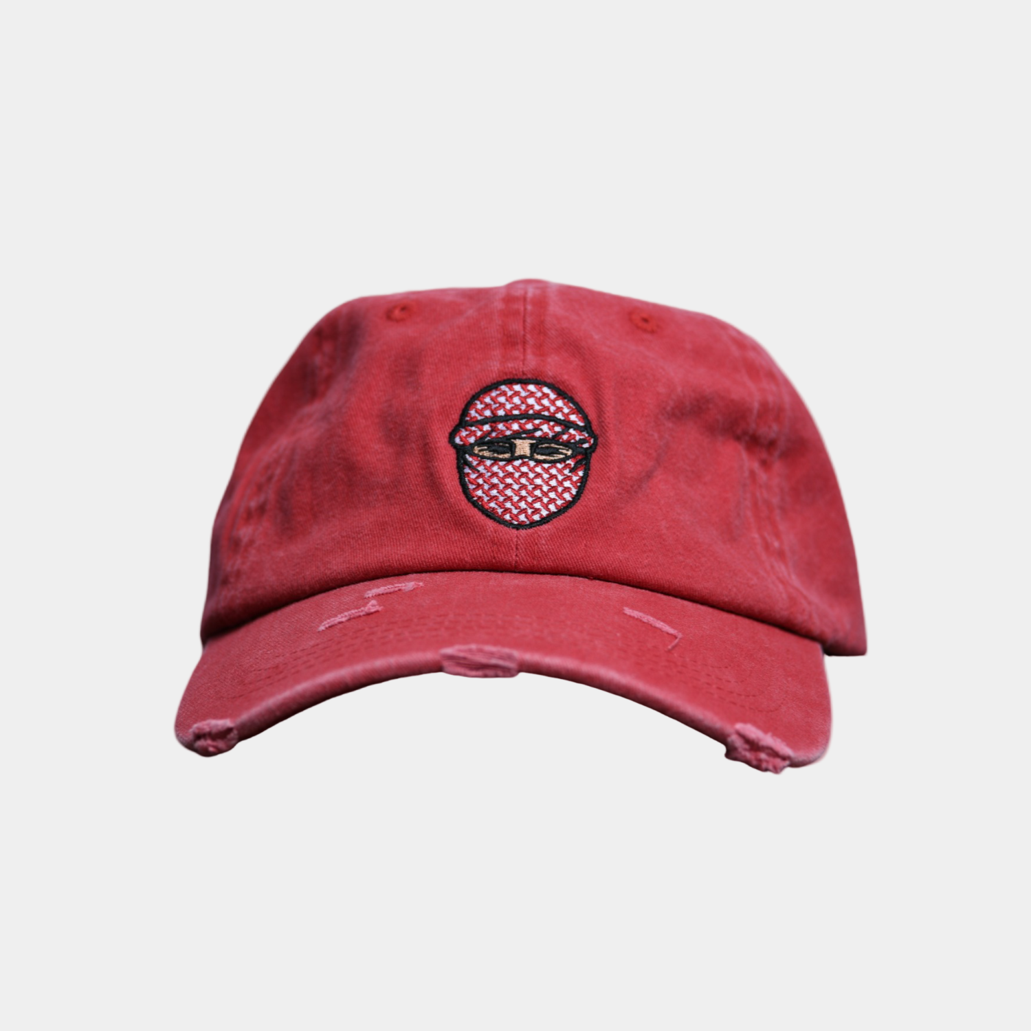 Red distressed baseball cap with a graphic design on a light gray background